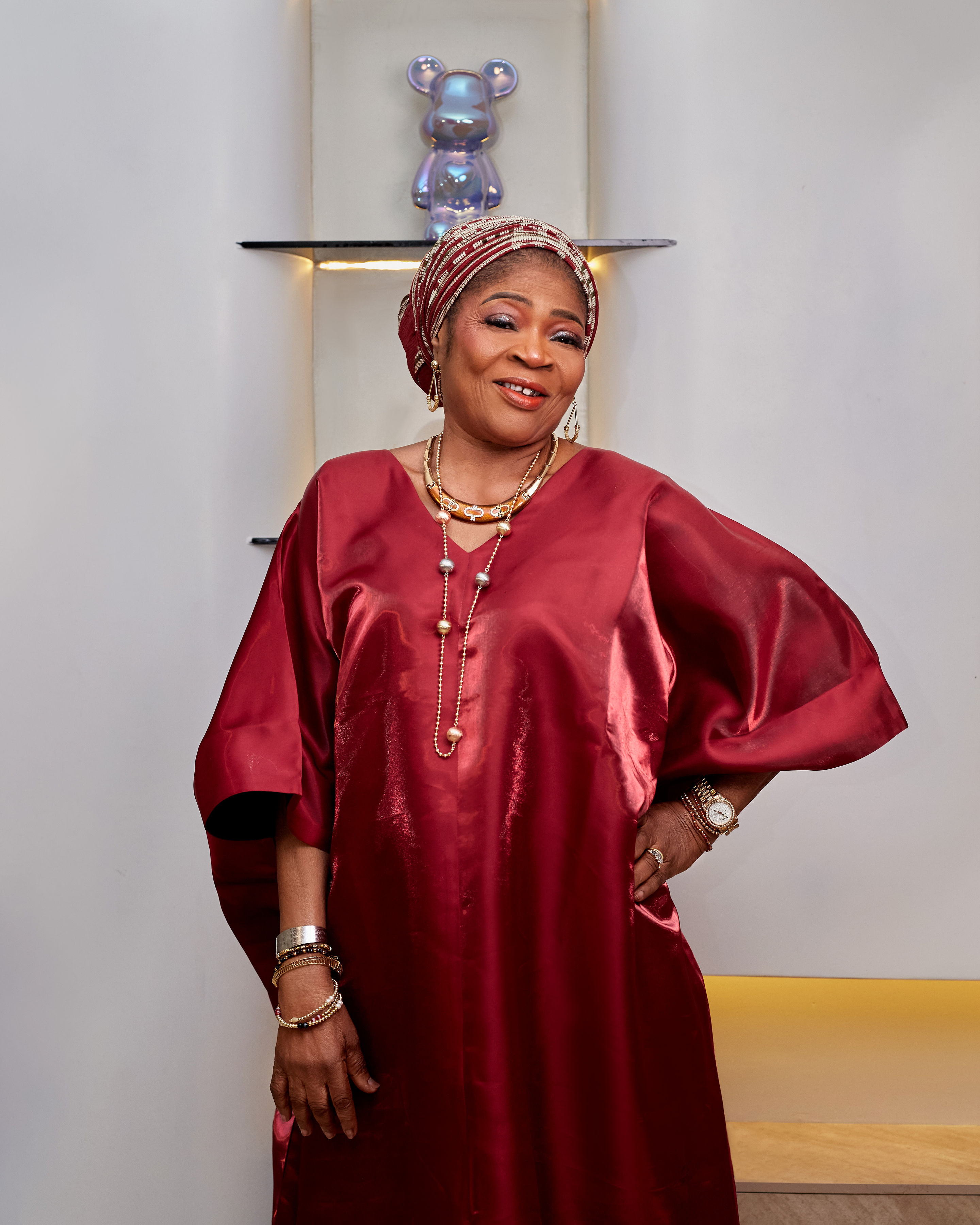 In a red satin boubou and beaded gele